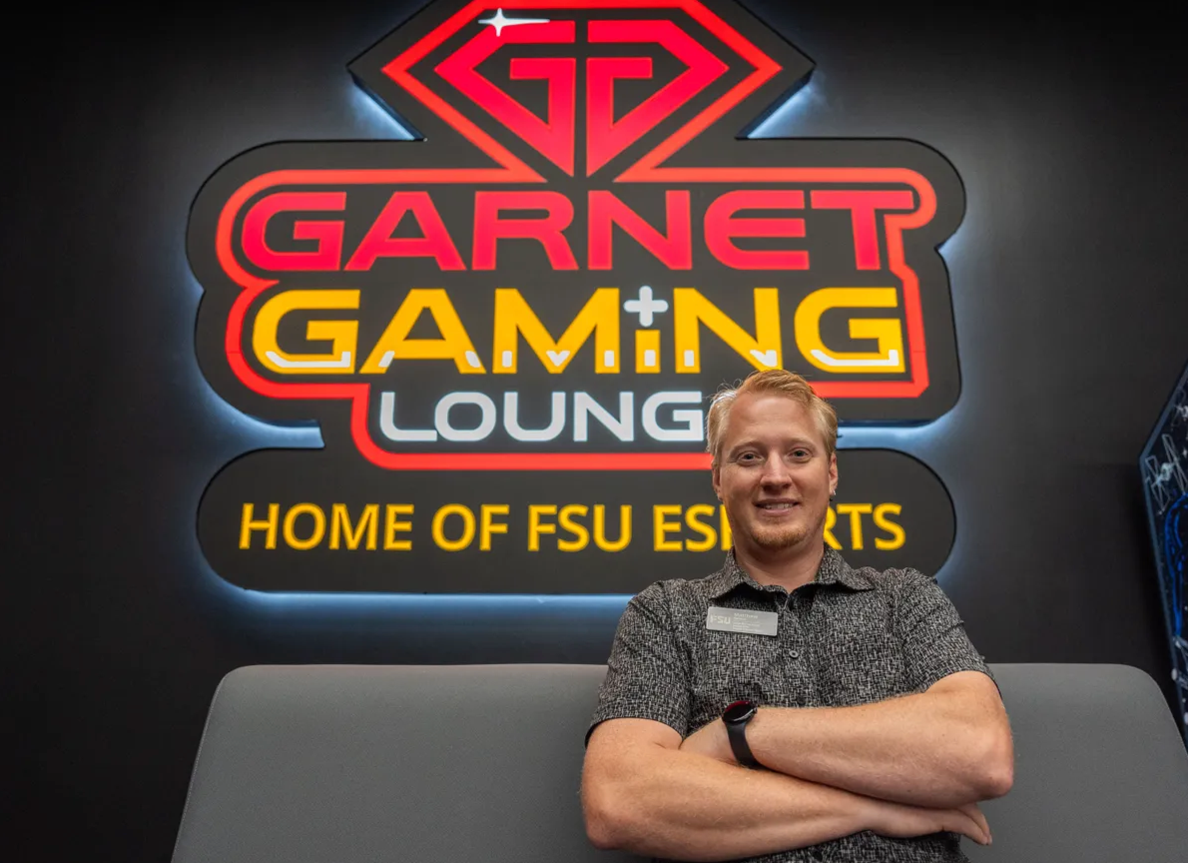 Matthew Nelson standing in front of Garnet Gaming Lounge sign
