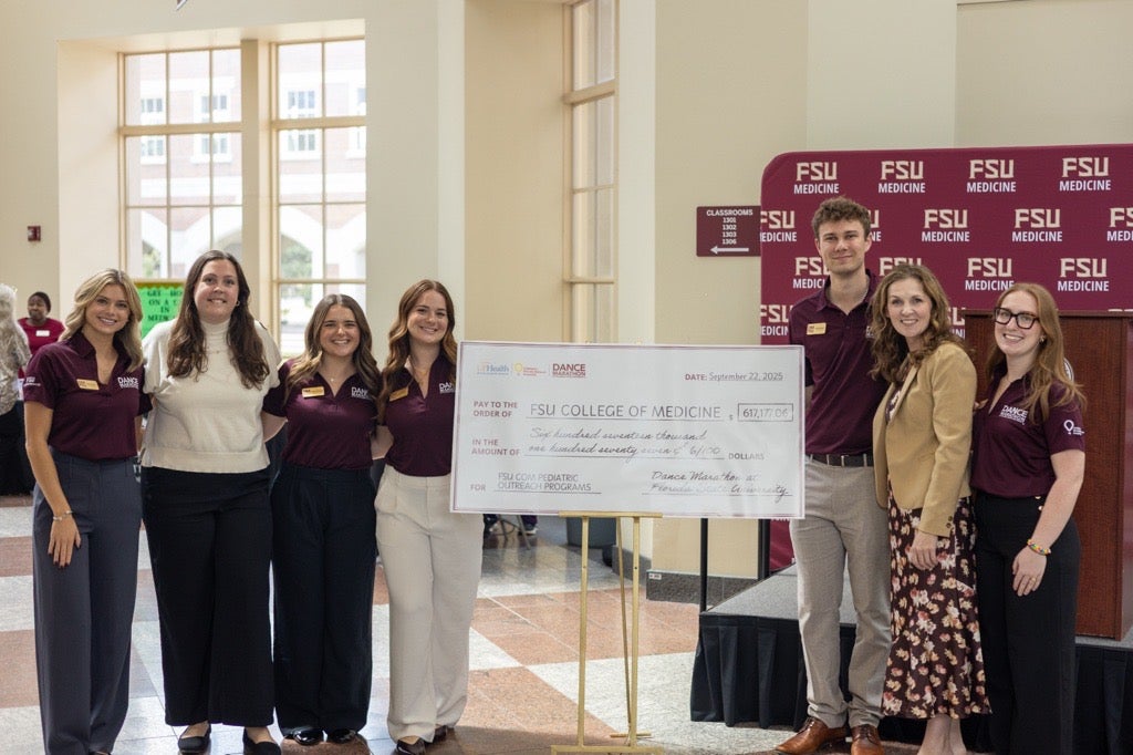 students and staff standing around a novelty-size check
