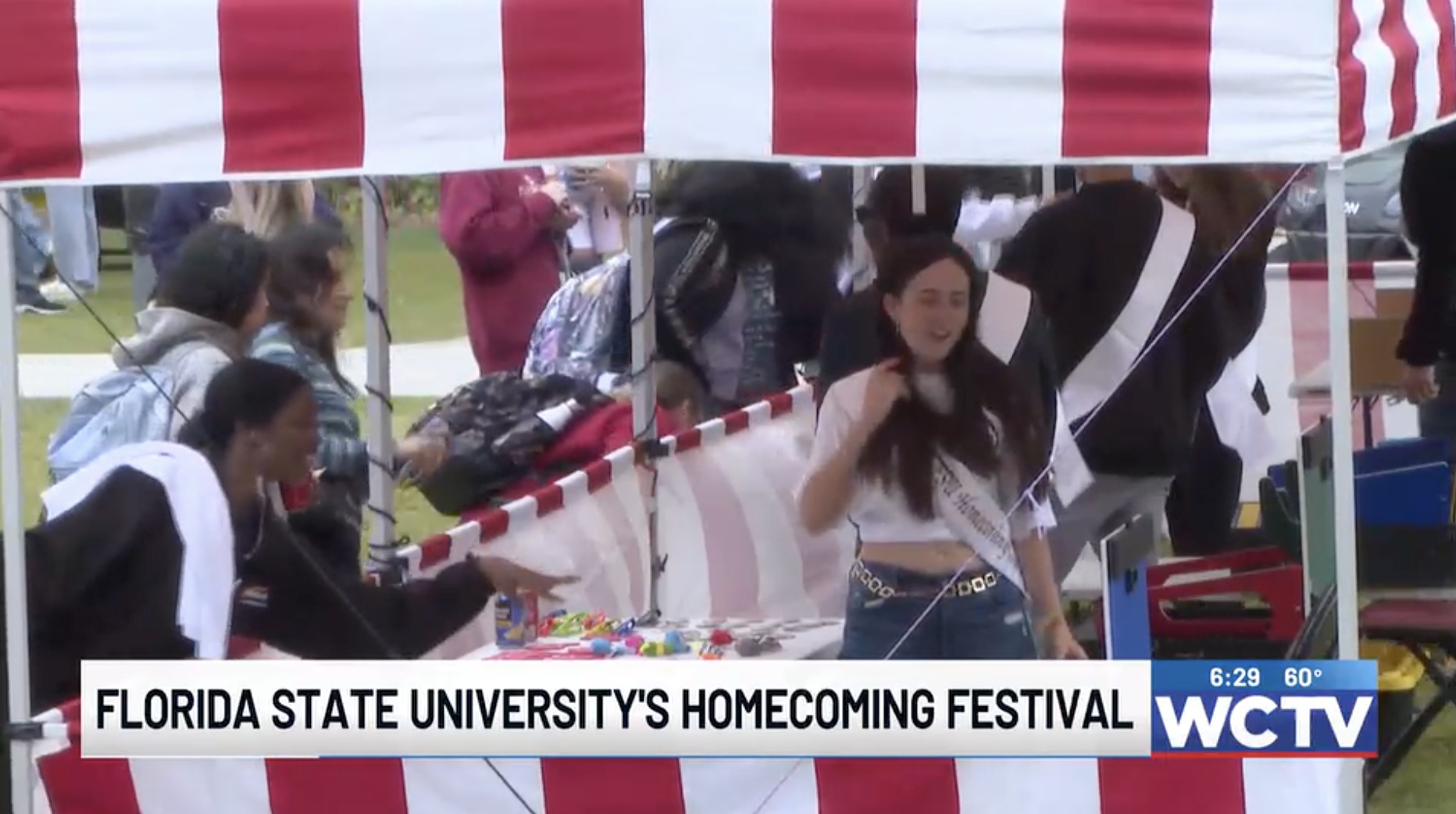 red and white striped tent with students playing carnival games