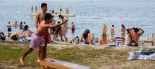 two students throwing underhanded at a shoreline