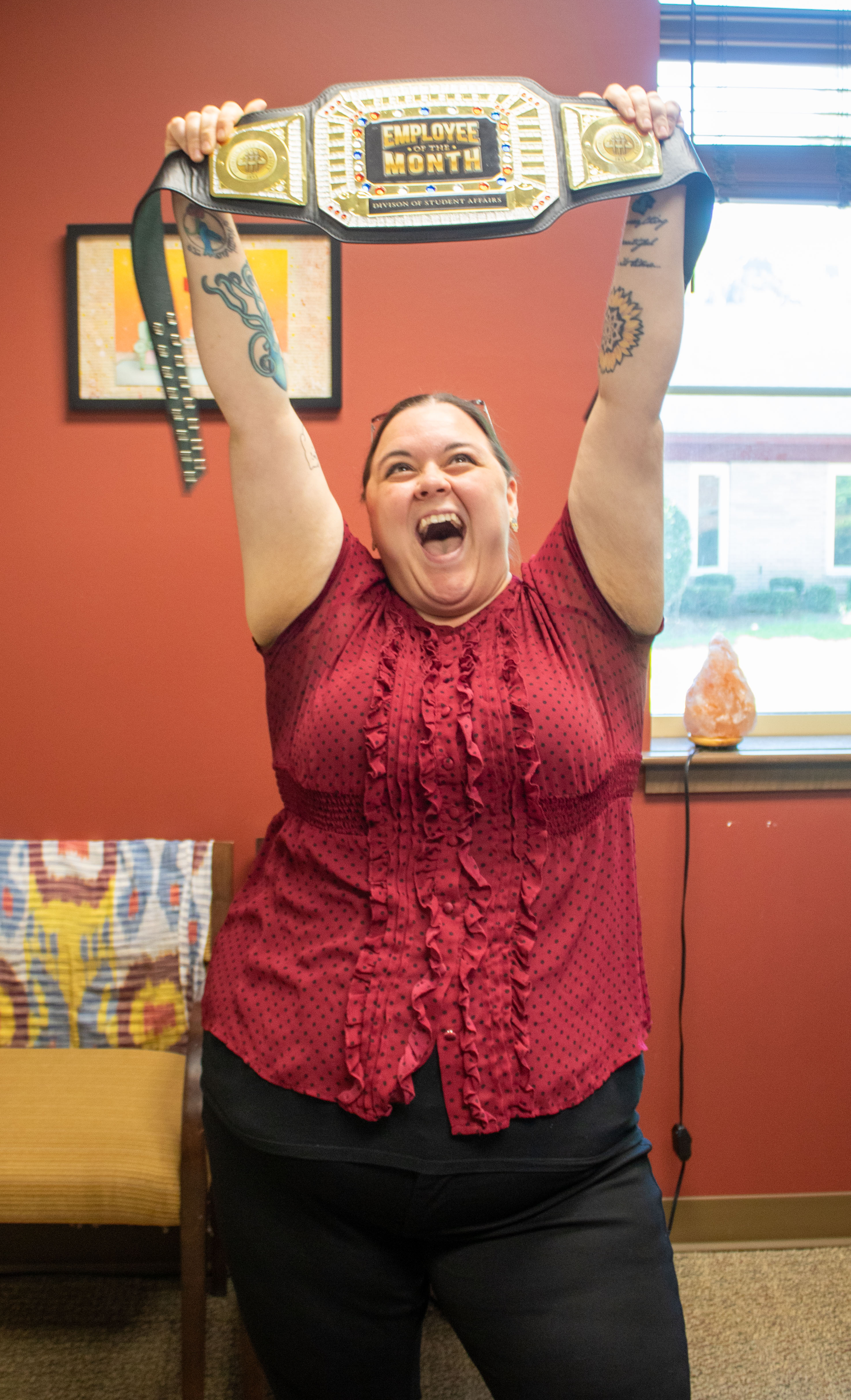 Michelle Lawson holding Employee of the Month belt above her head and yelling