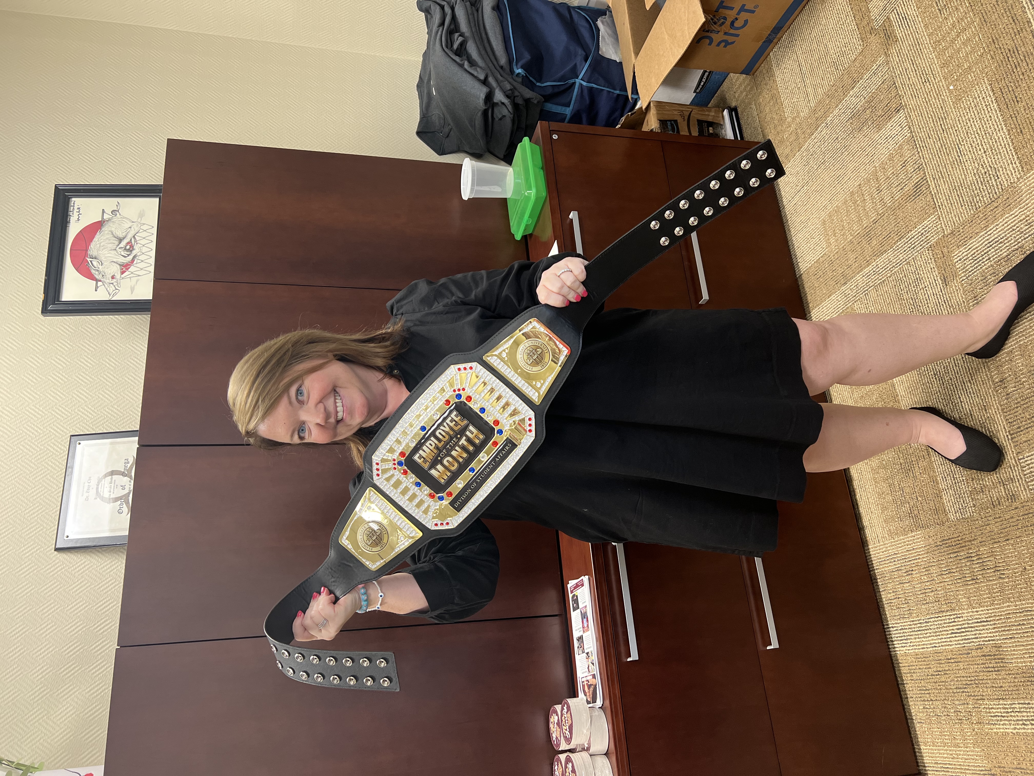 Robyn Brock holding Employee of the Month belt