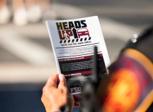 police officer holding heads up flyer