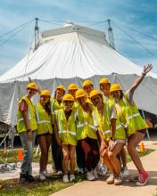 Students in high-vis gear stanfing in front of a newly-raised circus tent